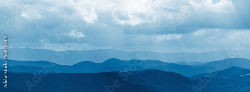 Beautiful nature panorama of dark blue mountain landscape. Horizontal image.