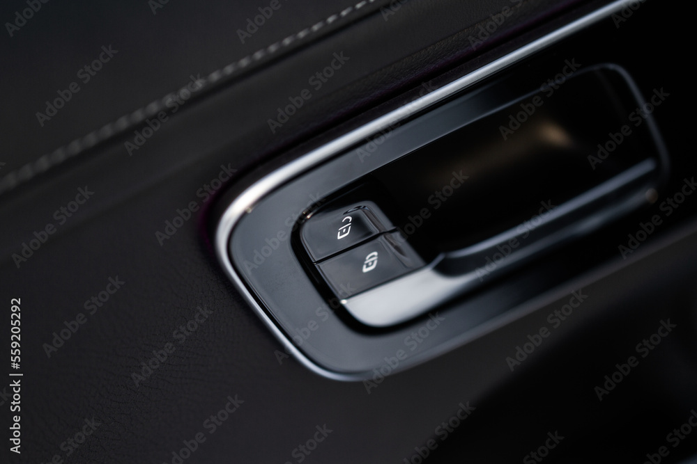 Car door lock unlock button close up. Modern car door lock. Door control panel in a new car. Car door lock unlock button close up. Modern car door lock. Door control panel in a new car.