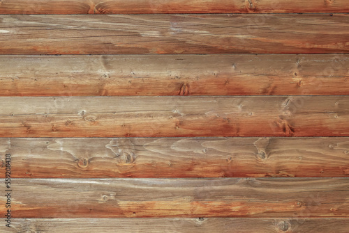 Wooden log house as a background.Wooden background from round logs with natural wood pattern