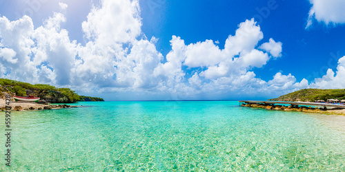 Sunny Caribbean tropical island beach with with pier and boat in Curacao