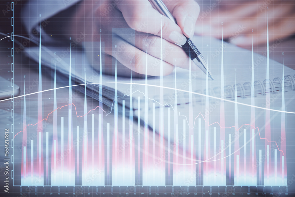 A woman hands writing information about stock market in notepad. Forex chart holograms in front. Concept of research. Multi exposure A woman hands writing information about stock market in notepad. Forex chart holograms in front. Concept of research. Multi exposure