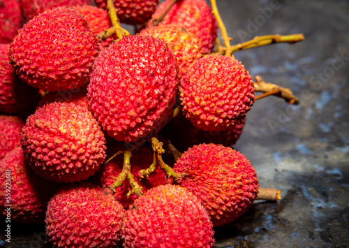Ripe lychee fruit  Litchi chinensis  isolated in dark background and selective focus. Red fruits