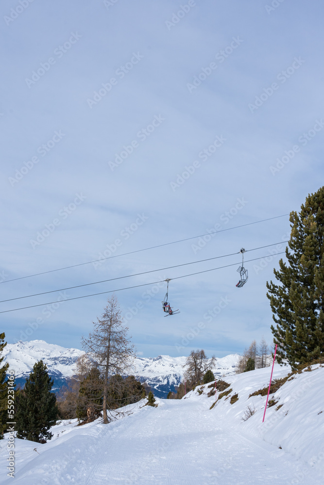 Chairlifts in winter with undefined skiers in ski resort. Chairlifts in winter with undefined skiers in ski resort.