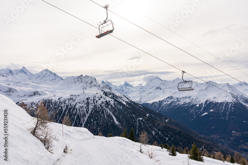 Red chairlift in winter with rear side of mount matterhorn in Switzerland.