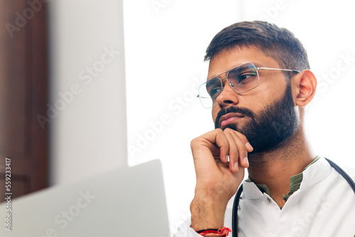 hispanic medical student in white coat with stethoscope in clinic