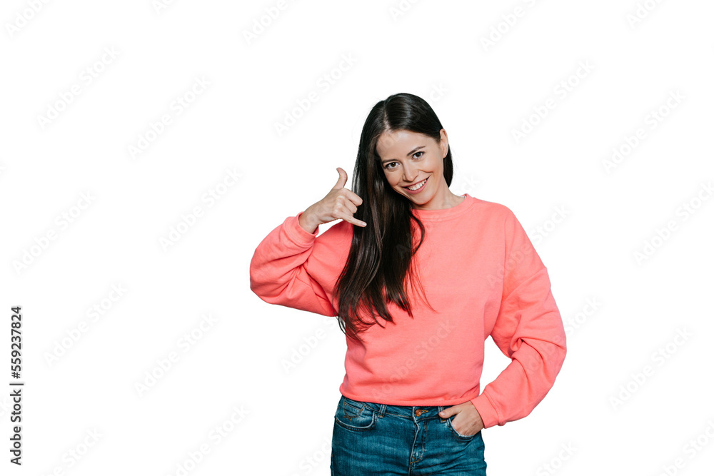 Smiling delighted brunette woman makes phone gesture, shows call me back sign with hand near ear, pretends talking on mobile phone, dressed in pink jumper, over transparent background. Smiling delighted brunette woman makes phone gesture, shows call me back sign with hand near ear, pretends talking on mobile phone, dressed in pink jumper, over transparent background.