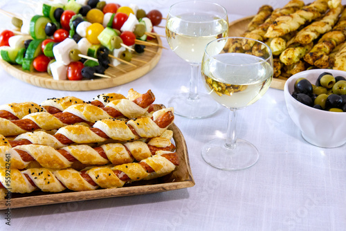Przekąski na przyjęcie sylwestrowe lub karnawał: kabanosy we francuskim cieście, paluszki z ciasta francuskiego i pesto, szaszłyki z pomidorami, oliwkami i serem serwowane z białym winem