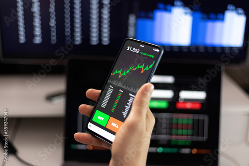 Businessperson using mobile phone app for stock market trade analysis