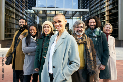 A group of smiling business people from a company led by an empowered shaved air woman. Cheerful Looking at camera portrait of a group of happy co-workers of diverse races and ages. High quality photo photo