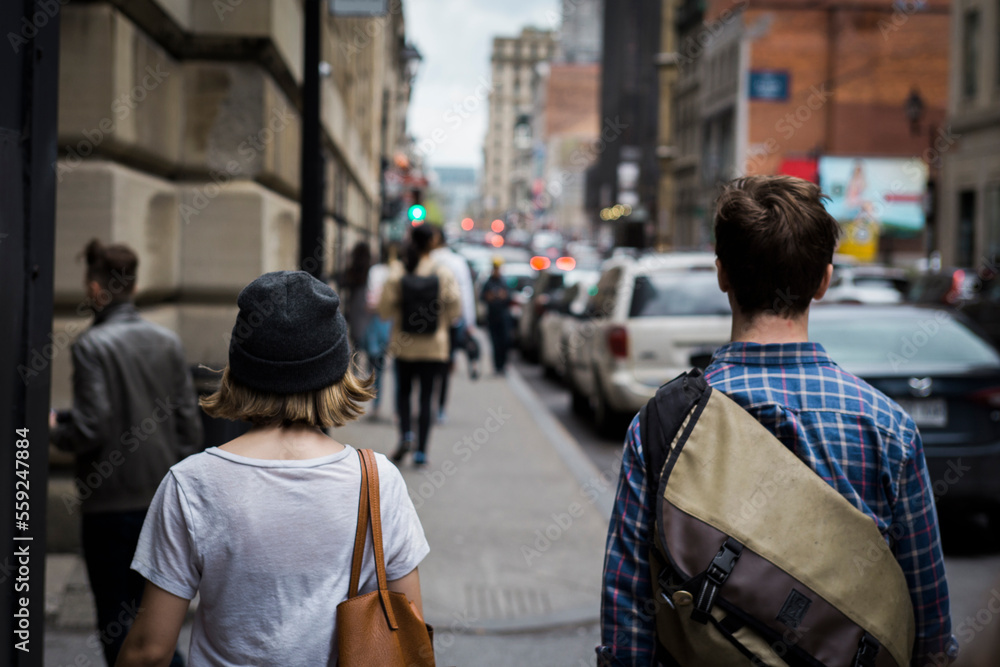 Rear view of friends walking on sidewalk in city Rear view of friends walking on sidewalk in city