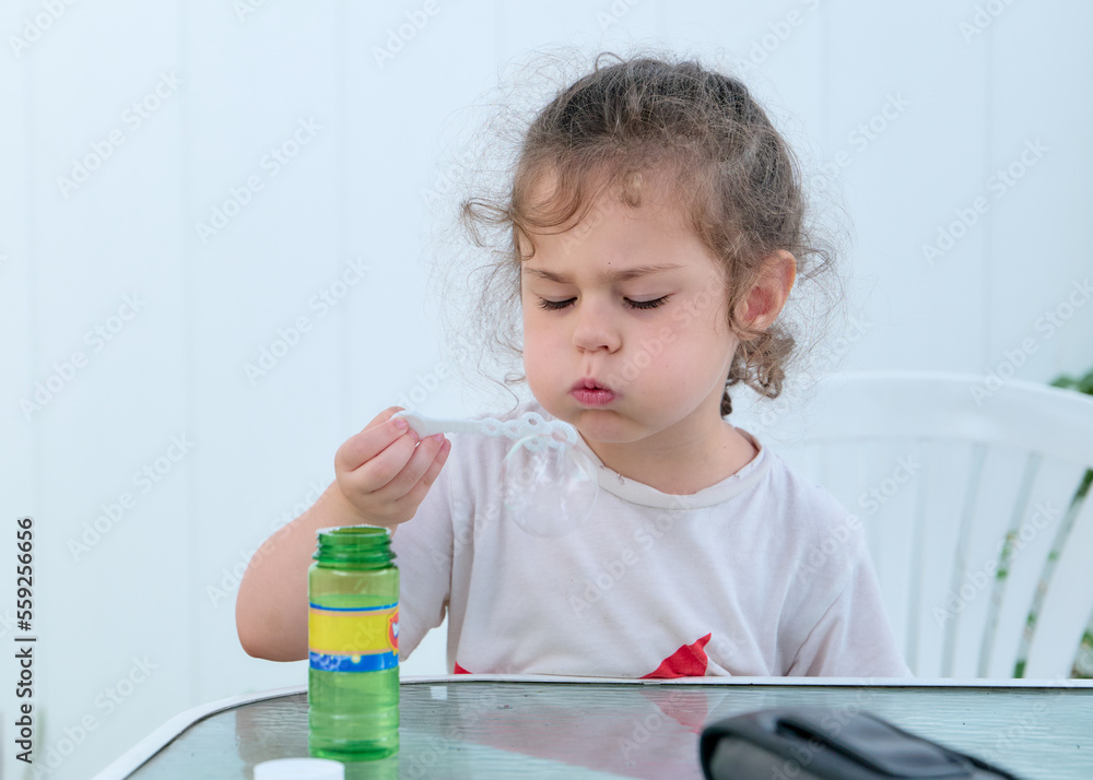 cute young baby girl playing with soap bubbles in the backyard cute young baby girl playing with soap bubbles in the backyard
