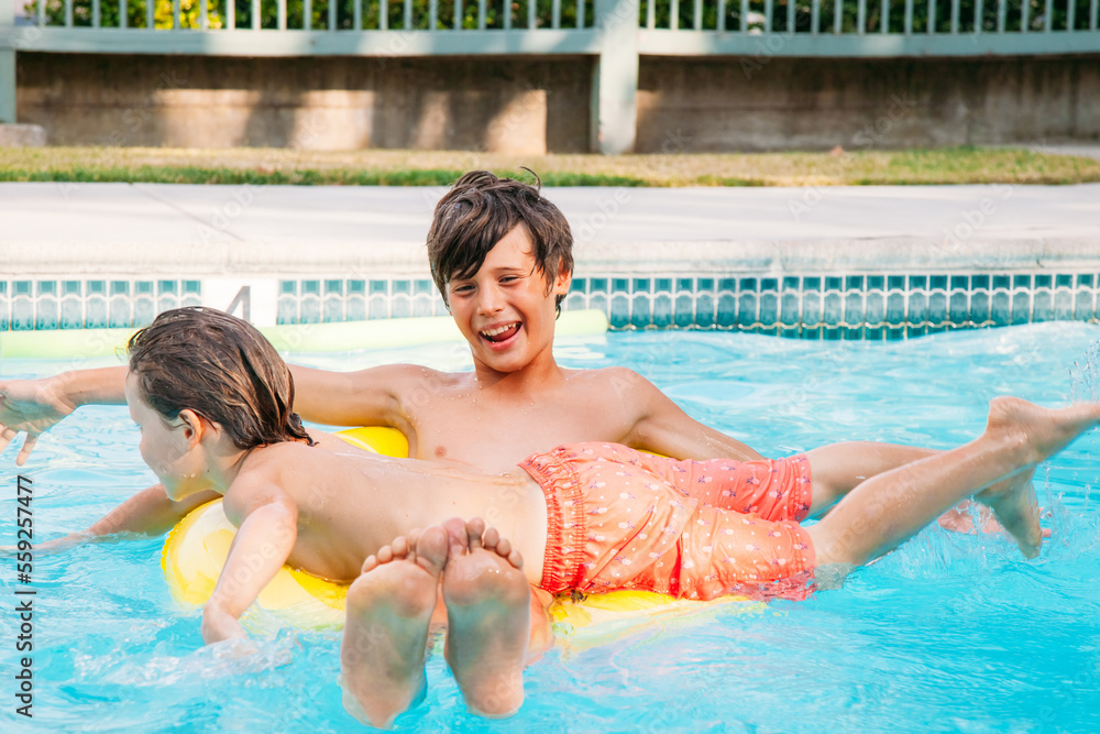 Two happy child having fun on summer pool. Boys playing at outdoor swimming pool Two happy child having fun on summer pool. Boys playing at outdoor swimming pool
