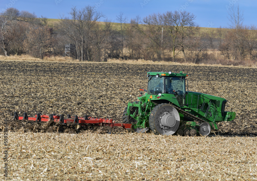 Fototapeta premium Track drive tractor pulling a disk chisel plow