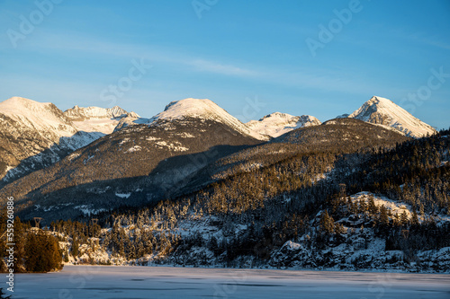 A snow range of mountains near frozen Green Lake with Wedge Mountain and and other peaks, near Whistler BC, Canada.