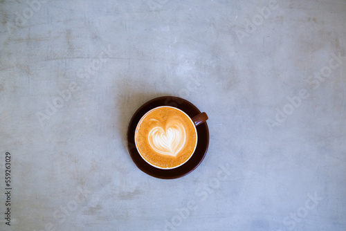 top view of cup of cappuccino with beautiful latte art on concrete background.