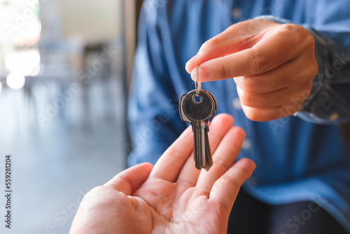 Closeup image of a real estate agent giving the keys to owner or buyer