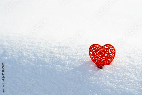 Red heart in snow. Valentines day card, February 14 background. Red frozen heart on white snow background. Velvet Valentine