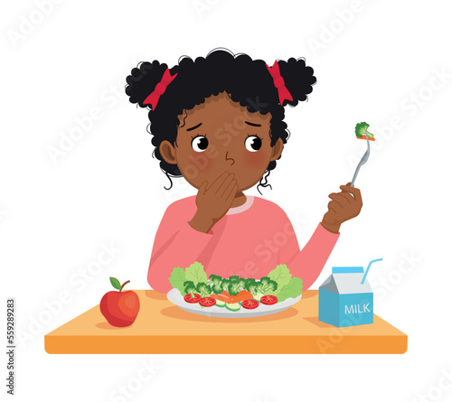 Cute little African girl picky eater refusing to eat vegetables