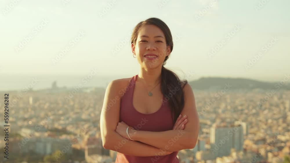 Young smiling woman crossing her arms and looking at the camera while standing on the observation deck Young smiling woman crossing her arms and looking at the camera while standing on the observation deck