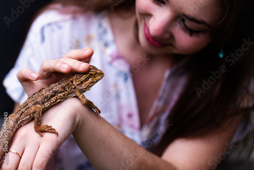 Woman interacting with pet bearded dragon lizard