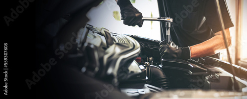 Fotografija Close-up hand auto mechanic using the wrench to repairing car engine problem