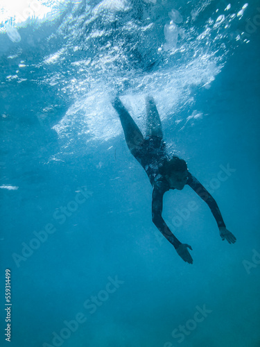 Female underwater in ocean wearing full piece swimsuit