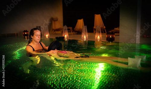 Therapeutic exercise in the pool. Woman receiving an aquatic therapy in the pool. Water relaxation and deep meditation. © jozefklopacka