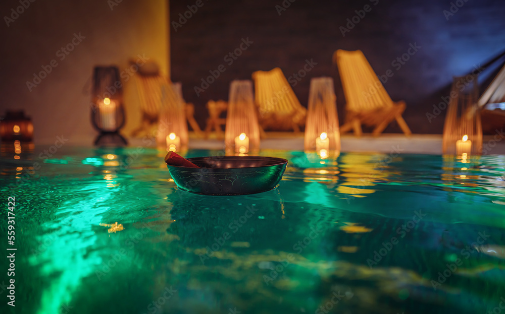 Tibetan bowl on the surface of the pool. Water relaxation and deep meditation.