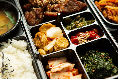 Beef bulgogi and various side dishes in a packaging container