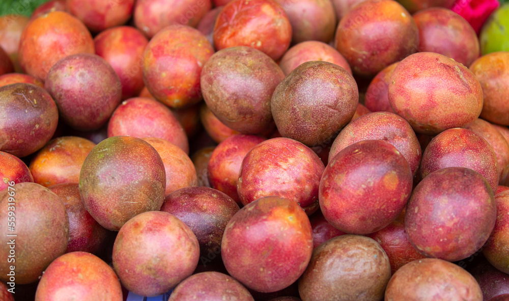 Passionfruit fruits close-up as a background. Bunch of tropical fruits harvesting. Passionfruit fruits close-up as a background. Bunch of tropical fruits harvesting.