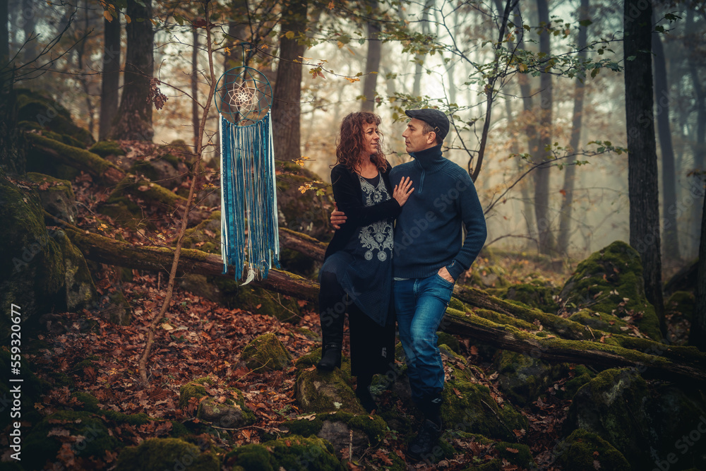 romantic couple in love in a misty forest, with a dream catcher.