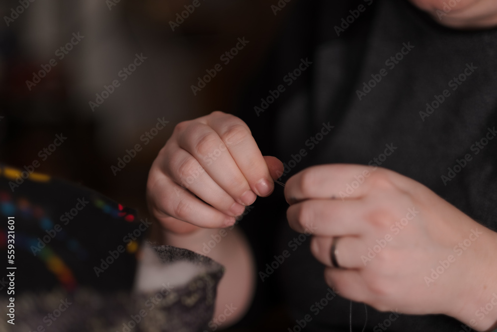 Obraz premium K. sewing at home.