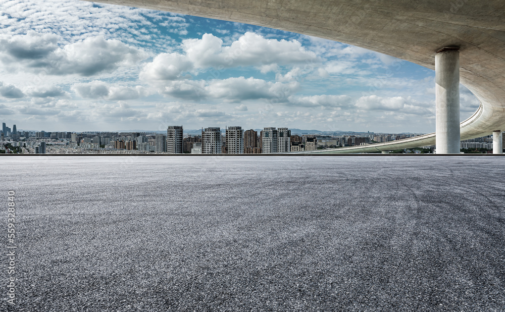 Asphalt road and bridge with city skyline background