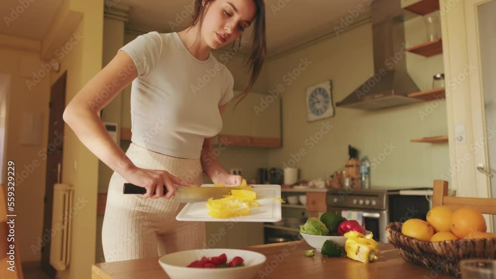Young woman preparing salad at home in the kitchen Young woman preparing salad at home in the kitchen