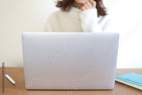 パソコンの前で悩む女性