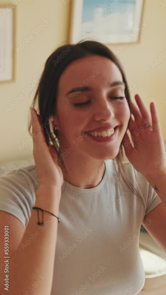 VERTICAL VIDEO, Young beautiful woman in headphones enjoys music and moves in dance VERTICAL VIDEO, Young beautiful woman in headphones enjoys music and moves in dance