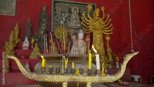 A candle burns in the Budi temple
