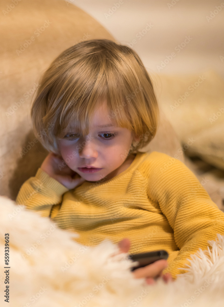 Portrait Of A Concentrated 3 Year Old Blond Boy Watching Video On Smartphone Portrait Of A Concentrated 3 Year Old Blond Boy Watching Video On Smartphone