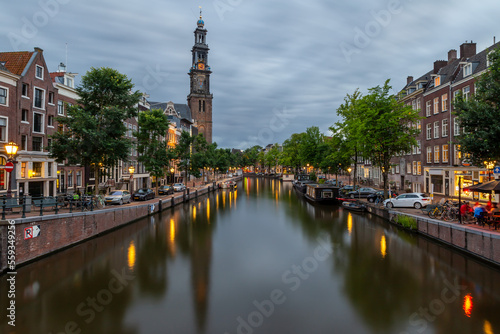 evening view on prinsengracht in amsterdam with westkerk lanterns reflecting in the water