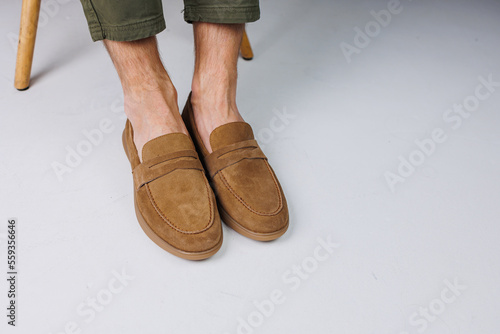Male feet in brown suede casual shoes. Men's fashionable shoes