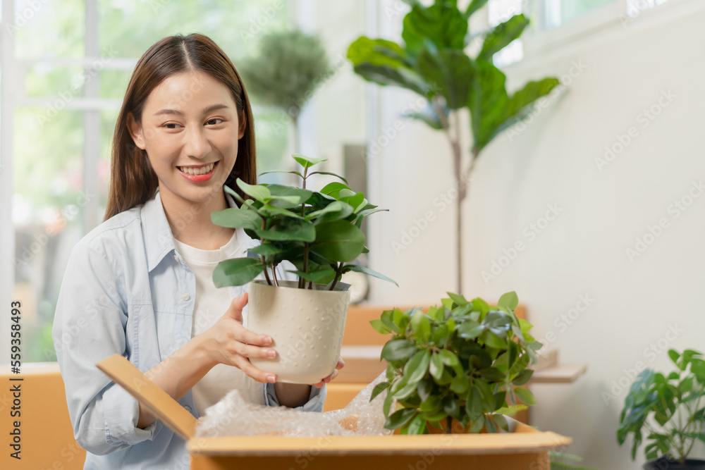 Happy asian young customer woman hand received, unpack package carton, parcel cardboard box by hand, holding ceramic plant pot. Moving, preparing in new house, relocation. Online shop delivery at home Happy asian young customer woman hand received, unpack package carton, parcel cardboard box by hand, holding ceramic plant pot. Moving, preparing in new house, relocation. Online shop delivery at home