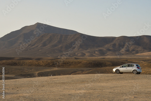 Lanzarote volcanic landscape with the Los Ajaches volcano in the background and a car in the foreground
