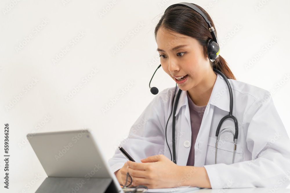 Doctor or physician wearing white coat, stethoscope using headset, consulting health by telehealth online for speaking video call consultation on tablet. Telemedicine by medical for distance patient. Doctor or physician wearing white coat, stethoscope using headset, consulting health by telehealth online for speaking video call consultation on tablet. Telemedicine by medical for distance patient.