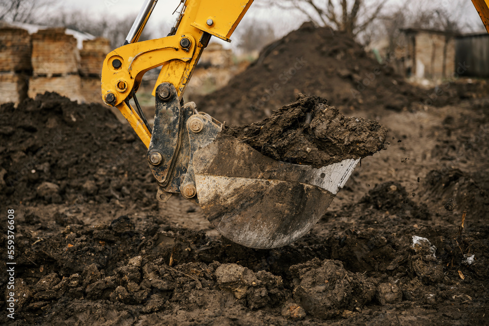 Close up of an excavator digging foundation on construction site. Close up of an excavator digging foundation on construction site.