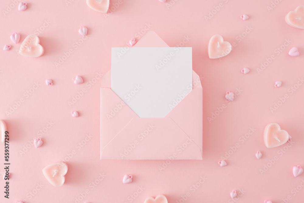 St Valentine's Day concept. Top view photo of heart shaped candles, heart baubles on pastel pink background and envelope with letter in the middle. Lovers holiday card idea. St Valentine's Day concept. Top view photo of heart shaped candles, heart baubles on pastel pink background and envelope with letter in the middle. Lovers holiday card idea.