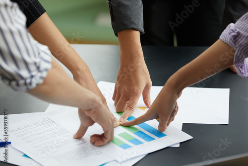close up businesspeople hands focus and pointing at important document in the office