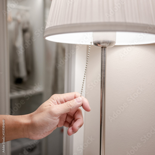 Murais de parede Male hand turn off the light on torchiere lamp in bedroom