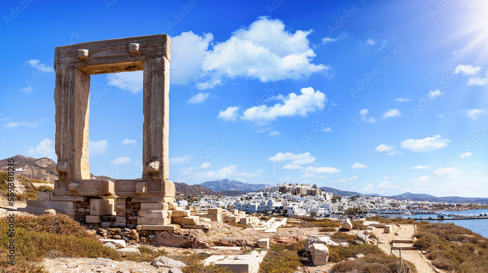 Panorama of the famous gate of Naxos island, so called Portara from the temple of Apollon, in front of the whitewashed houses of the city,  witout people, Cyclades, Greece