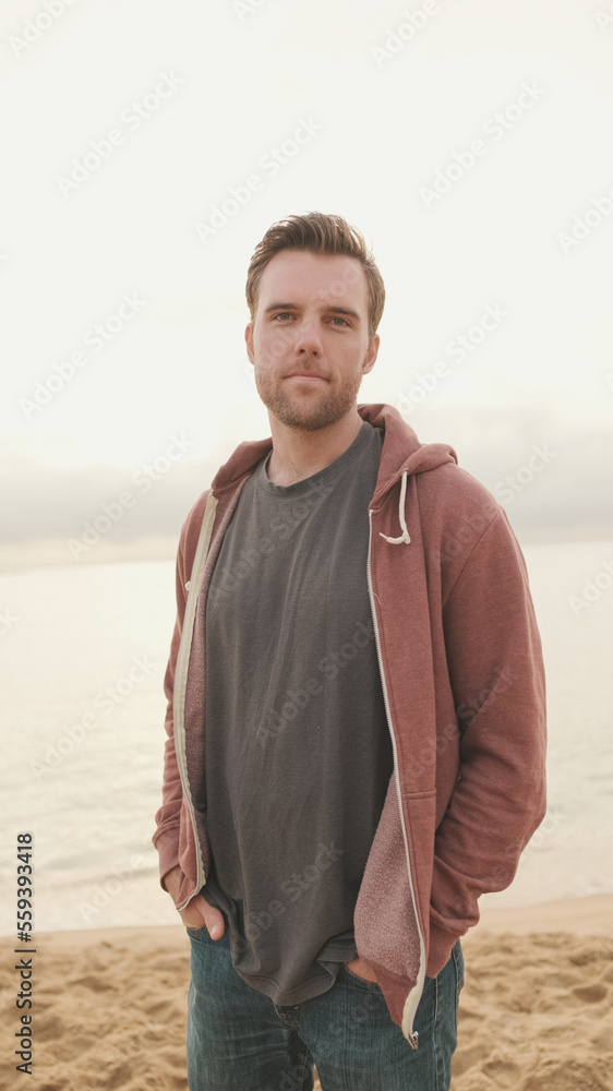 Close-up of young man standing on the shore and looking at camera Close-up of young man standing on the shore and looking at camera
