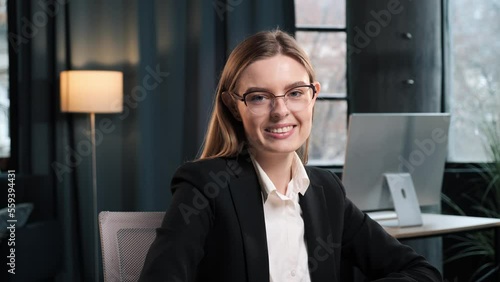 Close up of smiling beautiful businesswoman in formal suit, white shirt and eyeglasses looking at camera, showing self confidence, businesswoman feminism worker lady boss female leader possing inddor. photo